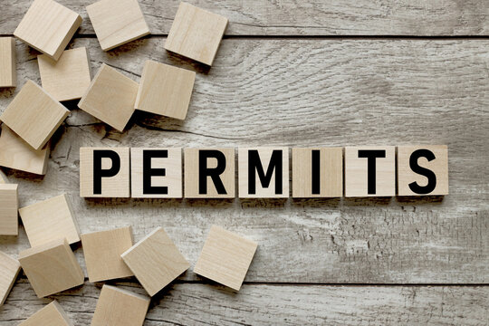 permits text on wooden cubes on wooden background
