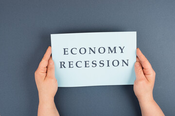 The words economy recession are standing on a paper, inflation and financially crash due  to...