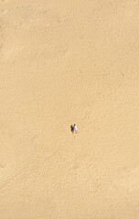 Aerial view of a young couple lying on the white sand. man and woman spend time together and travel through the desert