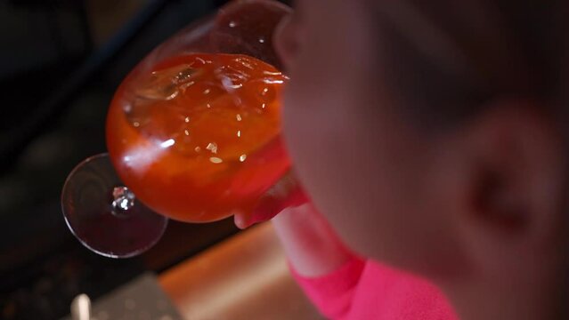 person drinks aperol spritz fresh orange cocktail with spaghetti