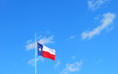 Texas flag flying high in the sky outdoors.