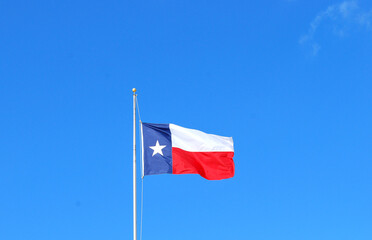 Fototapeta na wymiar Texas flag flying high in the sky outdoors.
