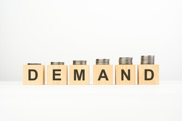 demand - text written on wooden block with stacked coins on white background, growing trend