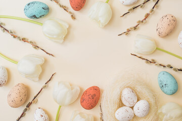 Flat lay easter composition with white tulips and easter eggs on a beige background