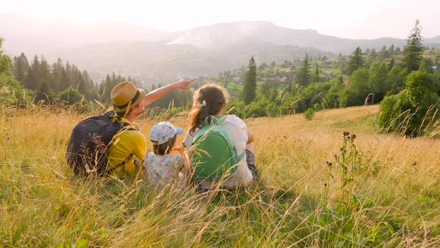 Free family looking at landscape travel Ukraine. Pointing family mountain vacation time together travel child and parents and kids. Hiking family vacation holiday summer travel local trekking mountain