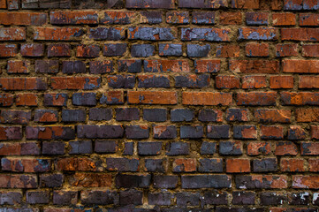 Very old brick wall. Dirty worn bricks.