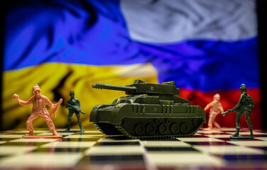 War between Russia and Ukraine, conceptual image of war using chess board, warring soldiers and tank, national flags on the background. 