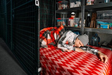 Man sleeping on mattress in underground emergency shelter