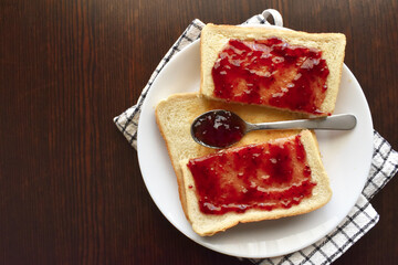 Toast with jam on a white plate. Food from above concept. Flat lay top view photo.