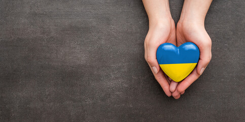 The woman is holding a Ukraine heart.