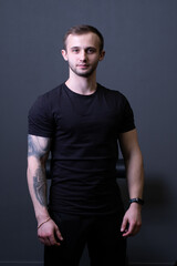 A guy standing in a black T-shirt is a beautiful sexy athlete handsome black man shirt blank, for healthy chest for young from muscular people, isolated sporty. Macho fashion standing, power adult