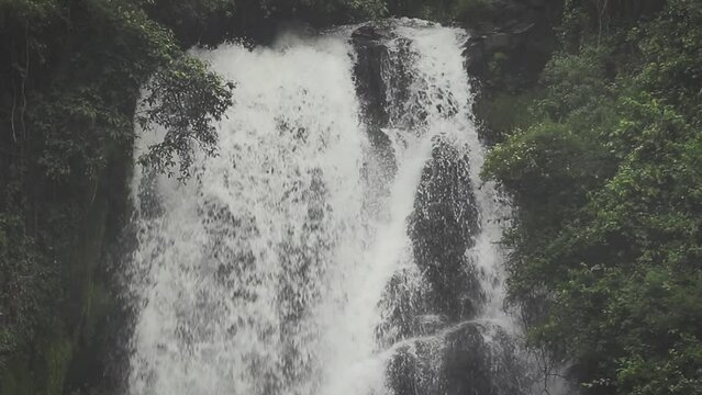 Slow motion video of Cascadas de Peguche, a small waterfall in a lush green environmnent in Ecuador, close to Otavalo.