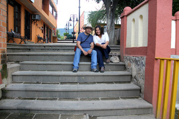 Latino man and woman couple stroll on their vacations they know the colonial streets of the magical town Jalpan de Serra in Querétaro Mexico enjoy their love in the Sierra Gorda
