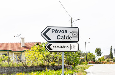 traffic signpost pointing the way to the village center of Póvoa de Calde (Calde) and the cemetery, district of Viseu, Portugal © Jorge Anastacio