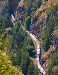 Train passes through a mountain. Freight train on a railway line on a mountain pass