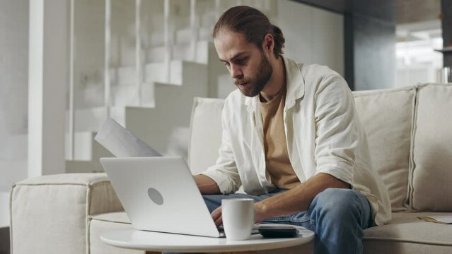 Focused man using laptop for counting domestic finance