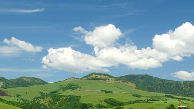 Hokkaido. A view of the blue sky and the magnificent ranch. Superb view drive. (pan)