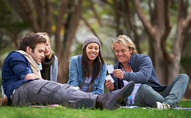 Naklejka premium Im about to win this game.... A group of friends enjoying an outdoor picnic together.