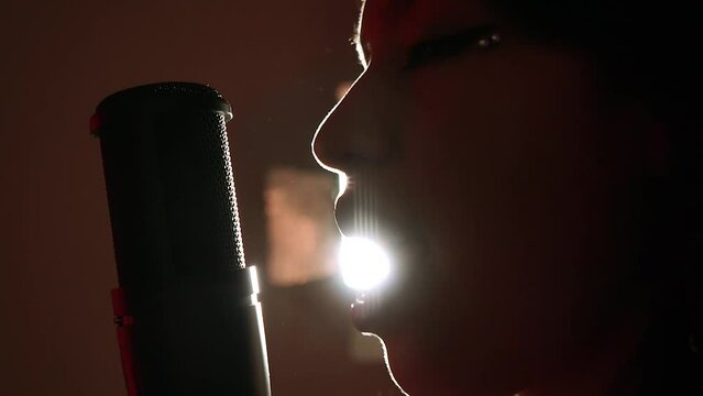 Mujer joven disfrutando del canto. Mujer cantando en estudio.