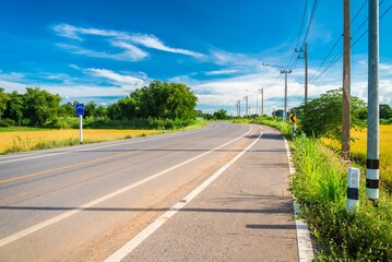Fototapeta na wymiar Beautiful empty curved country asphalt road, Thailand in sunny day blue sky background.