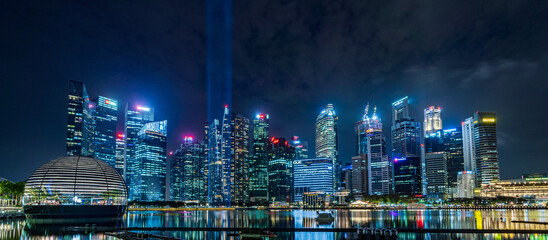Banner image of Singapore skyline with light display at night. - obrazy, fototapety, plakaty