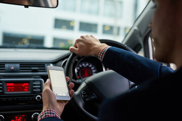 In contact on his commute. Cropped shot of an unrecognizable businessman using his cellphone while driving.