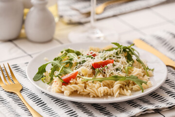 Plate of delicious pasta with arugula and cheese on table, closeup
