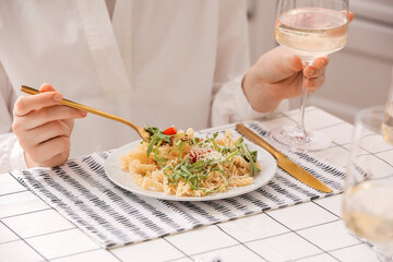 Woman eating tasty pasta at home, closeup