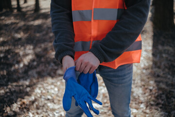 volunteer cleaner is cleaning up park and standing by bunch of garbage