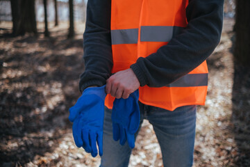 volunteer cleaner is cleaning up park and standing by bunch of garbage