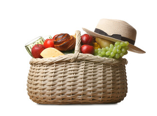 Wicker basket with tasty food for picnic and hat on white background