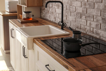 Cooking pot and cezve on electric stove in modern kitchen