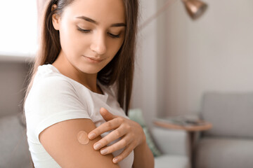 Young woman with applied nicotine patch at home. Smoking cessation