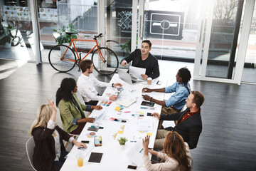Assigning a task to each team member. Shot of a group of businesspeople having a meeting in a...