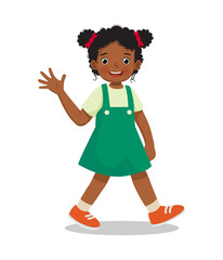 cute little African girl walking on the road greeting waving hand and smiling