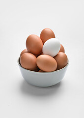 Bowl with chicken eggs on white background