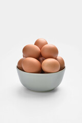 Bowl with chicken eggs on white background