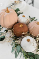 Decoration in boho style. Pumpkins on the table with eucalyptus and gypsophila. Stylish table decoration for the event.