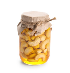 Jar of tasty cashew nuts with honey on white background