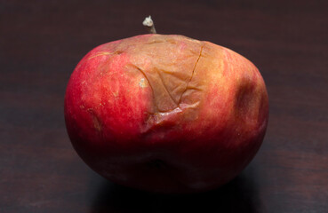 A red rotten apple. Spoiled fruit. The concept of death.