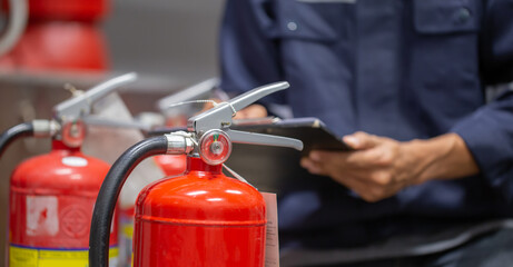 Engineer are checking and inspection a fire extinguishers tank in the fire control room for safety...