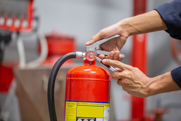 Engineer are checking and inspection a fire extinguishers tank in the fire control room for safety...