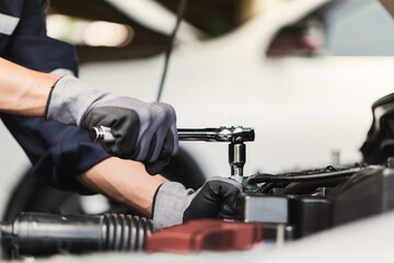 Professional mechanic working on the engine of the car in the garage. Car repair service.