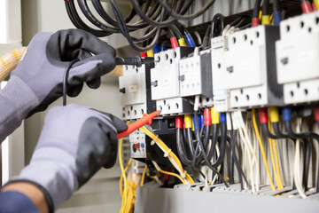 Electrician engineer tests electrical installations and wires on relay protection system....