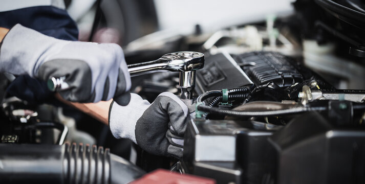 Professional mechanic working on the engine of the car in the garage. Car repair service.