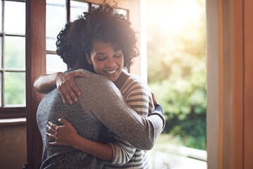 Missed you so much, babe. Shot of a young couple embracing by the doorway to their house.