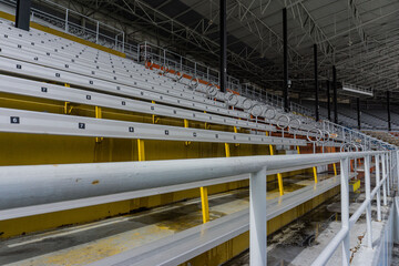 Large yellow and white shot of the bleachers with safety pole up close.