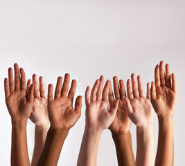 Raise your hands if you support diversity. Cropped shot of a diverse group of people raising their...