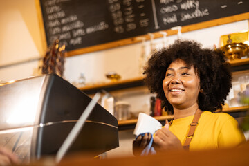 Young Female manager in restaurant with digital tablet or notebook.Close up of joyful African...