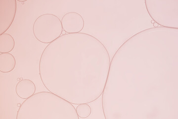 Abstract oil droplets on water surface creating bubble and circle shape with rose pink  light effects background.	